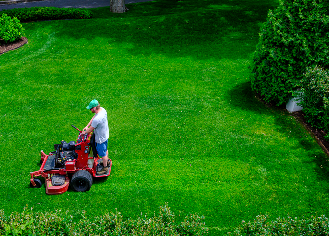 Eric Dean mowing very green grass.